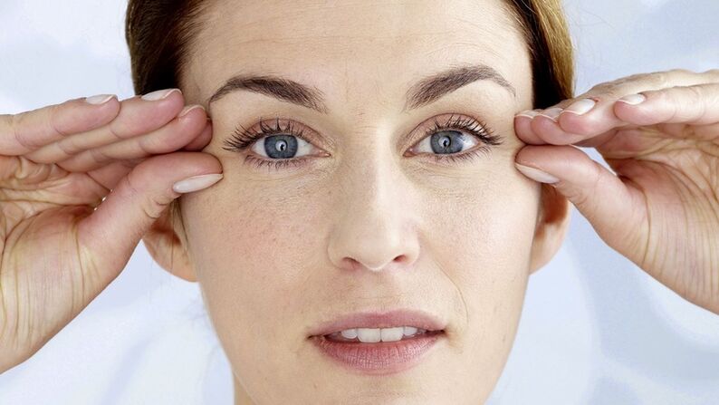 Uma mulher segura as mãos perto de seus olhos